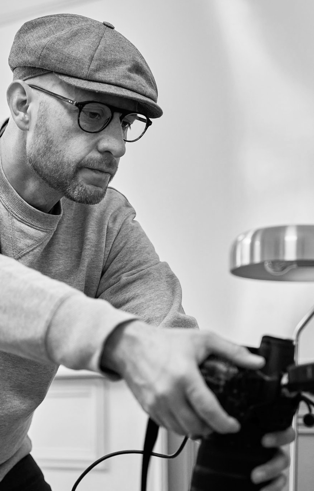 Antoine Ravet en pleine séance photo, concentré avec son appareil dans les mains.