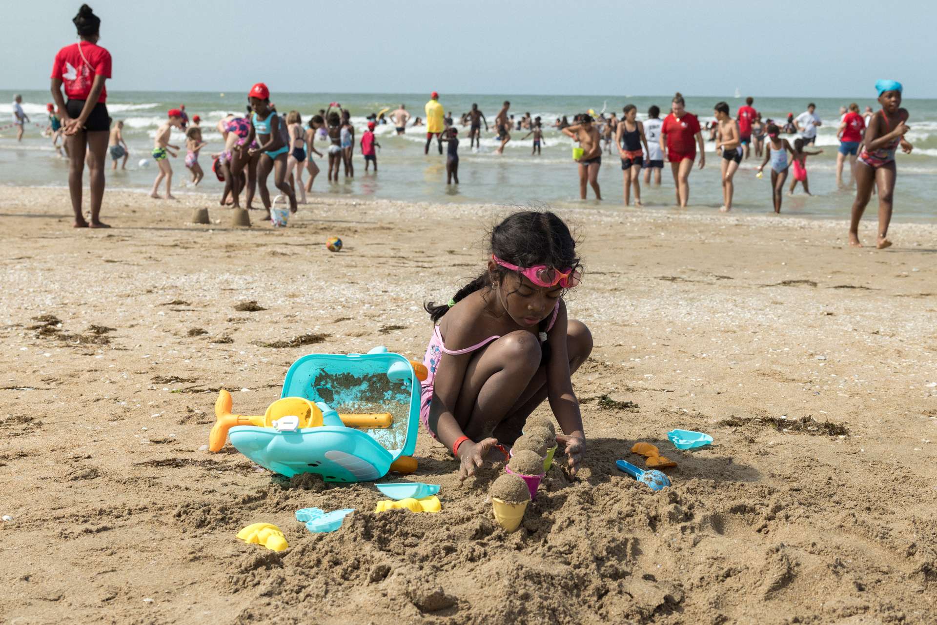 Enfant jouant à faire des chateaux de sable sur la plage.