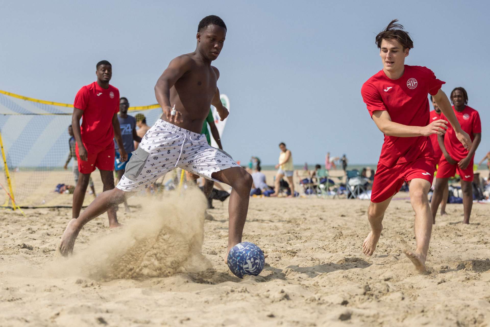 Joueurs de foot sur la plage.