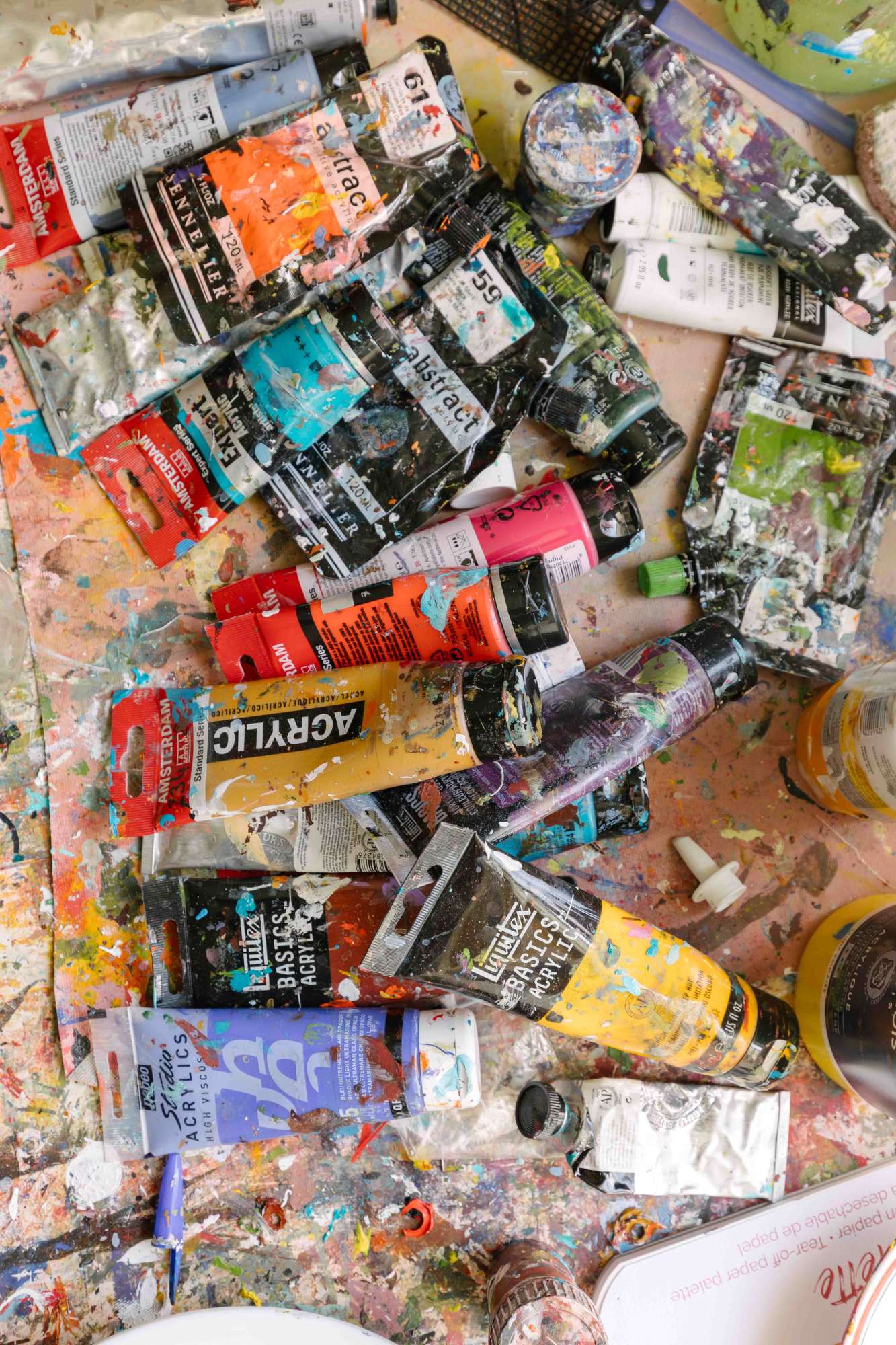 Photo de tubes de peintures avec des tâxches de couleurs arc en ciel